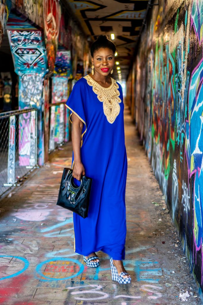 How to Wear an African Boubou, tips featured by top Atlanta fashion blogger, Hurry in Time: lady in blue boubou dress outside walking under a graffiti bridge