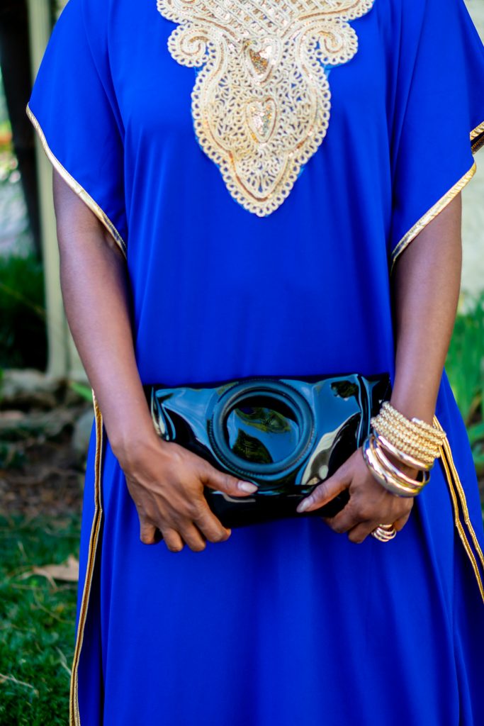 How to Wear an African Boubou, tips featured by top Atlanta fashion blogger, Hurry in Time: lady in blue boubou dress outside holding a black purse