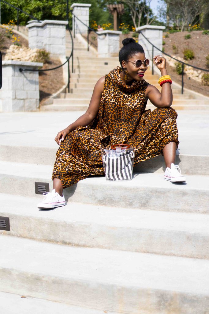 Herem Jumpsuit styled by top Atlanta fashion blogger, Hurry in Time: A woman wearing shades sitting on stairs out side
