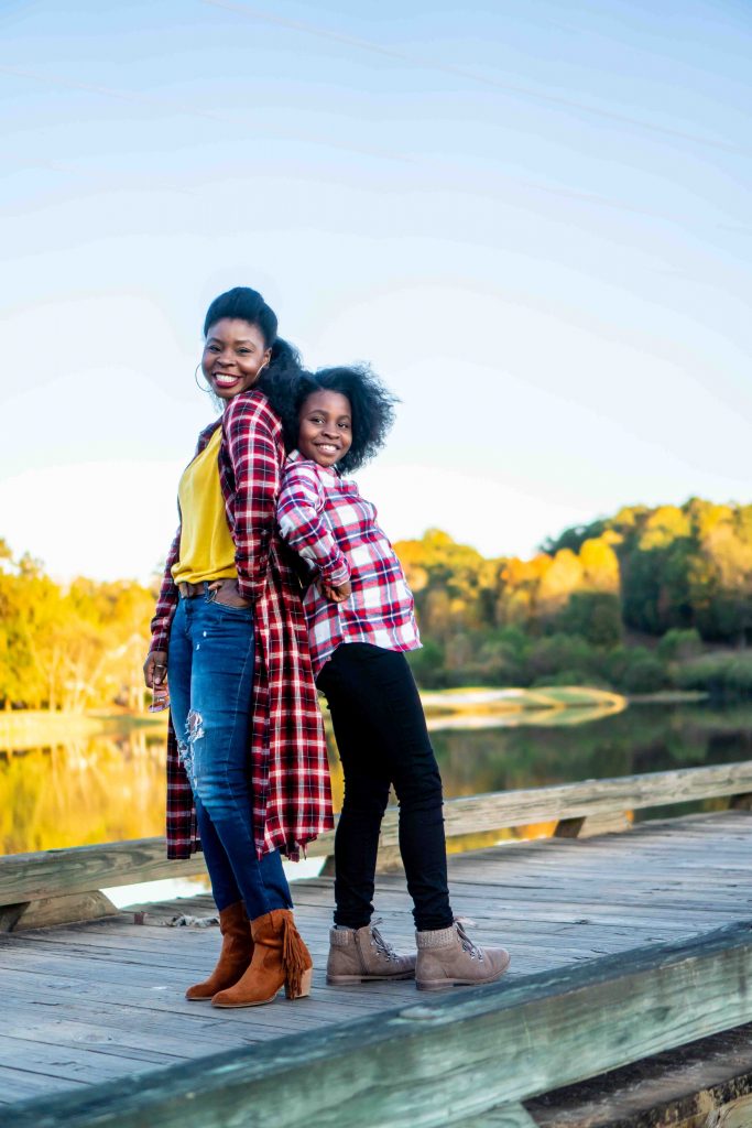 How to Address Family Nostalgia During the Holidays, tips featured by top Atlanta lifestyle blogger, Hurry in Time: Woman and girl standing on a bridge with their backs touching wearing red plaid.