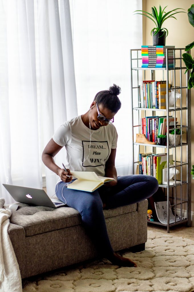 5 Tips for Working From Home and Homeschooling During Self-Quarantine featured by top Atlanta lifestyle blogger, Hurry in Time: Woman sitting on a couch looking in a notebook