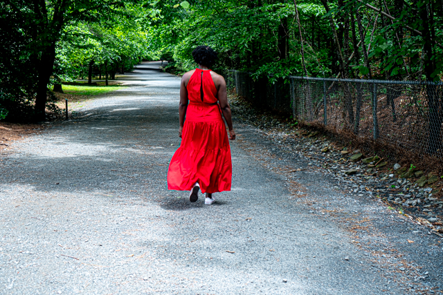 Woman in a red dress walking on a trail